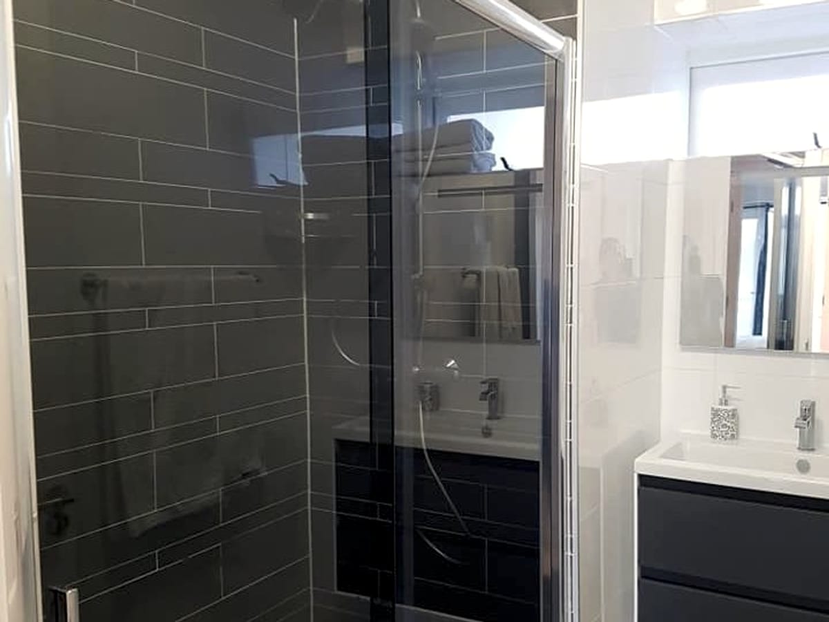 Modern bathroom with glass shower, basin and mirrored cabinet