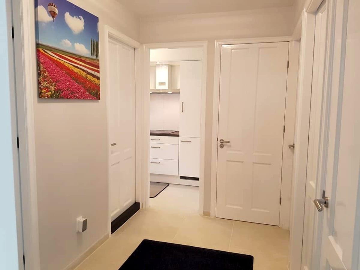 Bright hallway leading to a white fitted kitchen
