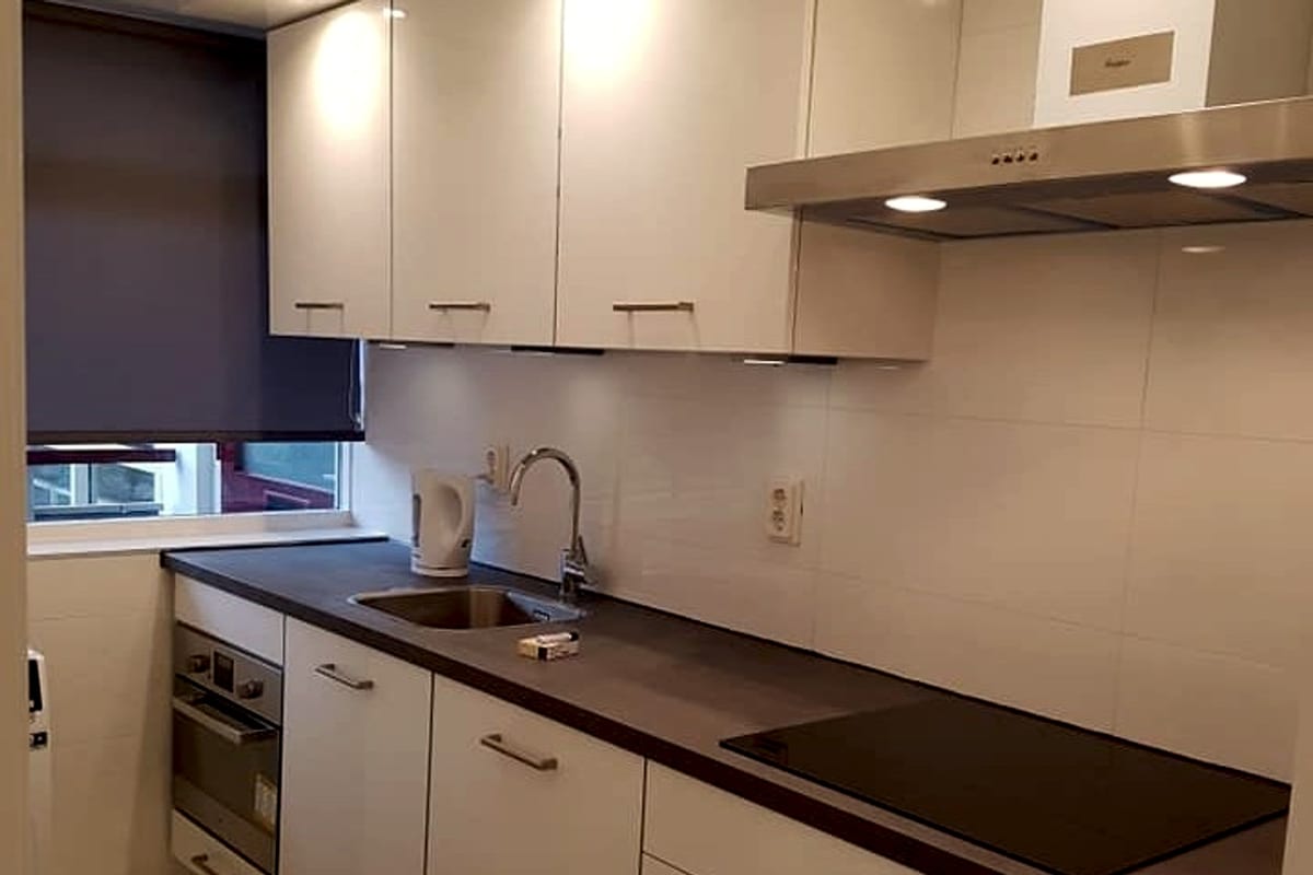 White fitted kitchen with induction hob, oven and sink