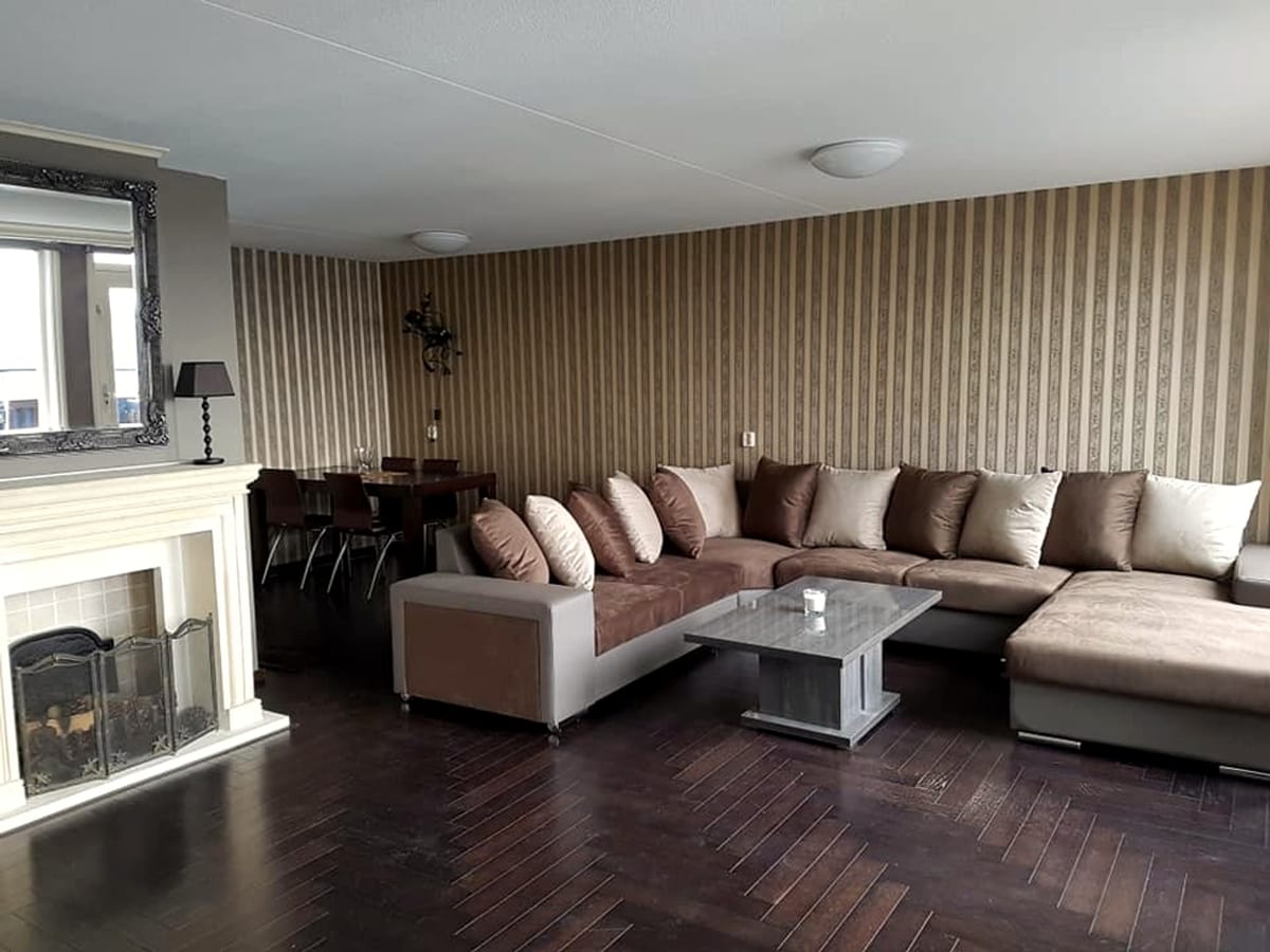 Spacious furnished living room with sectional sofa, fireplace and dining area